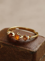 Three orange stone ring on a fine gold-tone band — VoxArcana